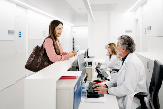 Patient checking in at hospital reception desk