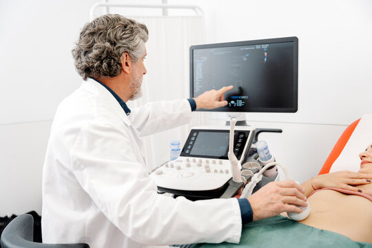 Doctor performing abdominal ultrasound on female patient