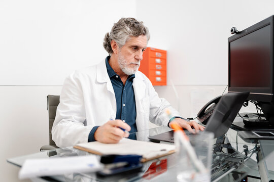 Doctor using laptop during medical consultation in office