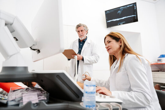 Gynecologist performing ultrasound examination on patient in clinic