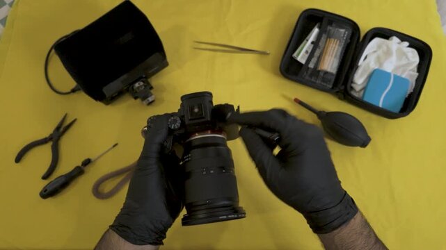 Brushing the buttons and dials of a professional camera.