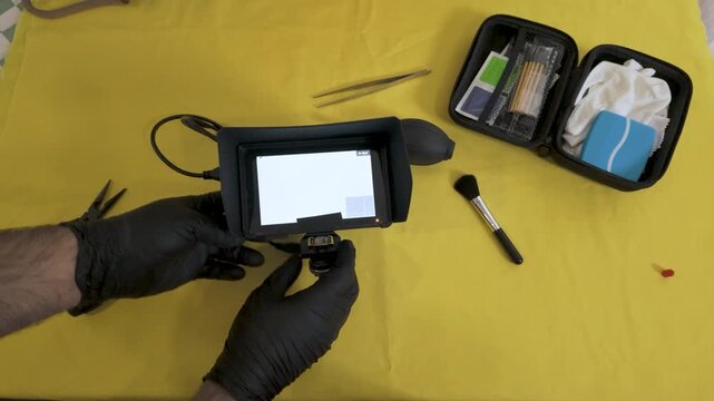 Using a manual air blower to clean the camera sensor area.