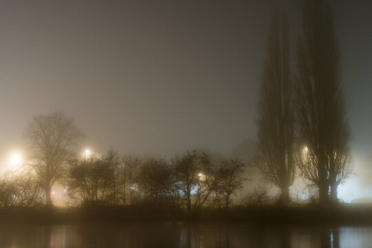 A river reflecting city lights on a foggy winters night