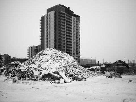 Snow Covers Rubble at Construction Site Near High Rises