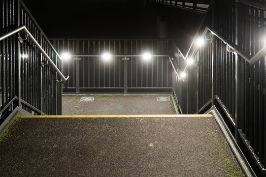 Steps on a modern foot bridge on a foggy winters night