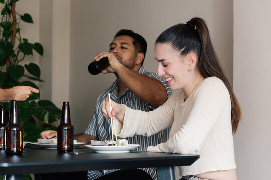 Friends eating sushi and drinking beer