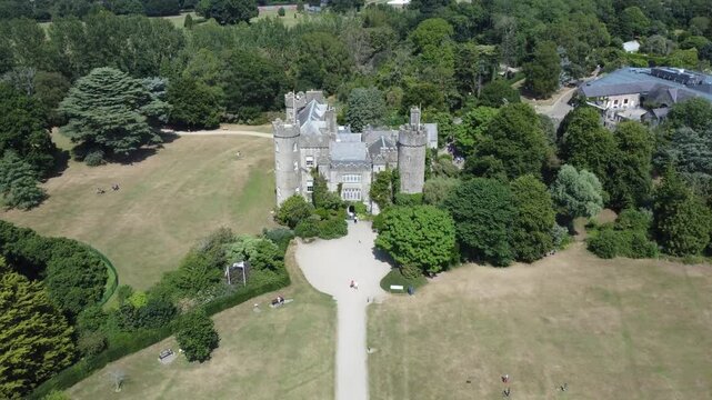 An aerial show of a castle in Ireland, the beauty of tree that involves the castle 
