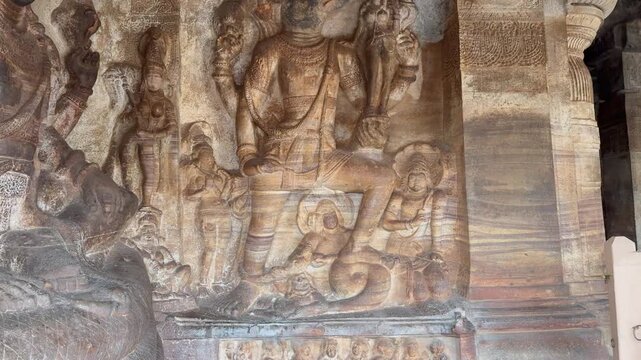 Varaha avatar of Lord Vishnu rescuing Bhudevi, gently carrying her on a lotus as she places her hand on his face in faith. Sheshnaag carved below. 1300-year-old Badami Caves, Karnataka.