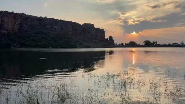 A slow-motion view of calm Agastya Lake, with gentle clouds drifting across the sky