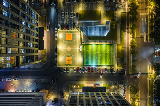 Top-Down Night View of Lit Basketball and Soccer Courts

