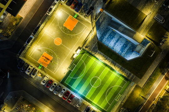Top-Down Night View of Lit Basketball and Soccer Courts

