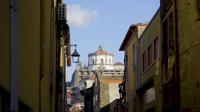Narrow street view framed by buildings looking towards the Monastery dome.