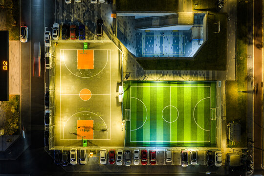 Top-Down Night View of Lit Basketball and Soccer Courts

