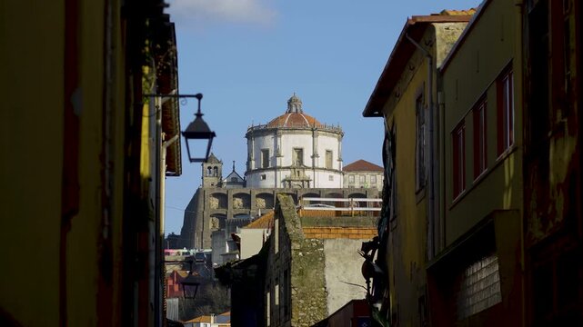 View of the Serra do Pilar Monastery through a narrow historic alley.