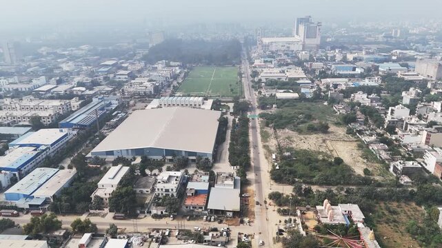 High-angle aerial of an industrial cluster in Greater Noida, highlighting warehouses, transport activity, and mixed land use, with visible haze underscoring ongoing air pollution across the region.