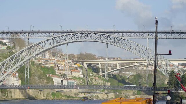 Wide panoramic view of the Dom Luis I bridge and Douro river banks.
