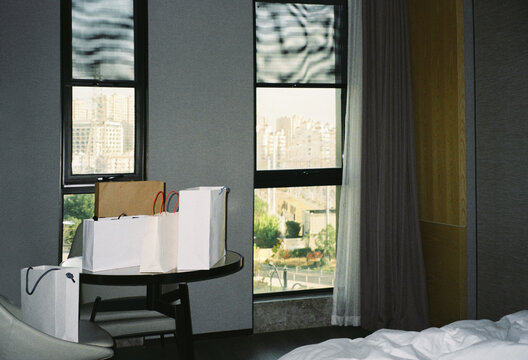 Room with shopping bags near window overlooking city