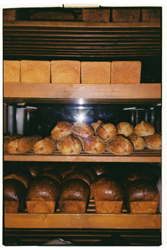 Fresh baked bread and rolls stacked on wooden shelves