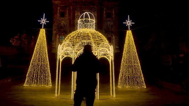 Bright golden dome light decoration in a public square at night.