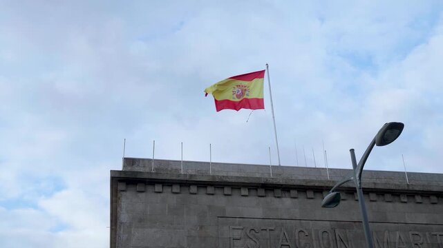 Spanish flag waving on top of a historic building in Porto.