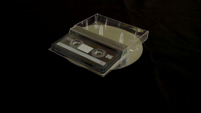 Close-up of a transparent cassette tape on a black background.