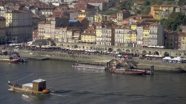 Panoramic view of the Ribeira waterfront with boats on the river.