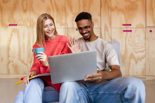 Multiracial friends enjoying a video call on a laptop