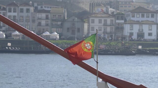 The Portuguese national flag fluttering above the Douro river.