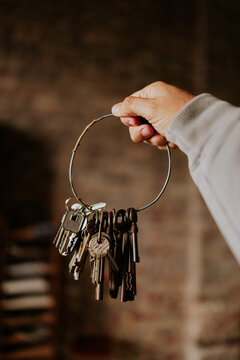 Hand holding a keyring full of vintage and modern keys