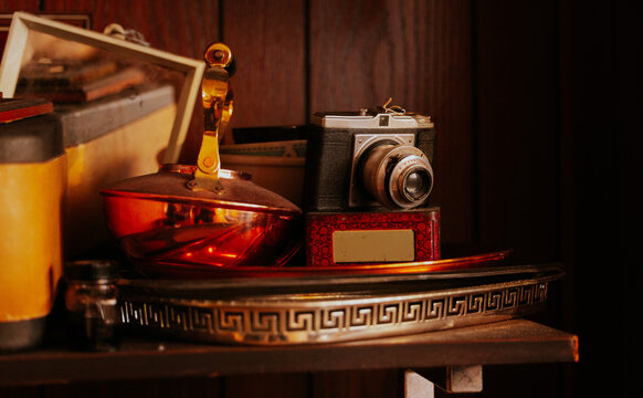 Vintage camera and brass items on wooden shelf