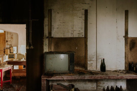 Abandoned room with vintage television and bottles