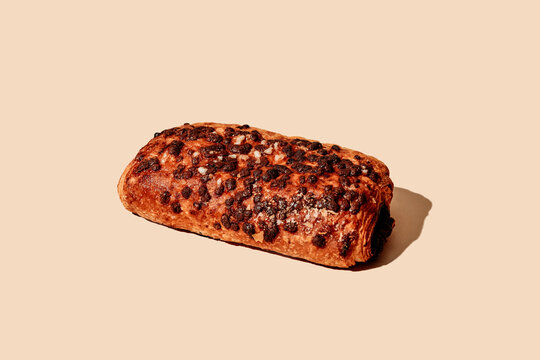 a pain au chocolat on a beige background