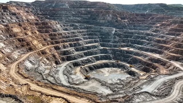 Aerial view of a large open pit mine with multiple layers and roads.