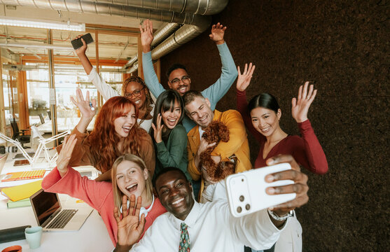 Diverse group taking a selfie in modern office setting