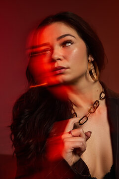 Woman in black outfit holding chain with motion effects in backg