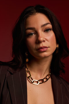 Portrait of a woman with earrings and a chain necklace