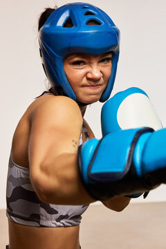 Female boxer practices a punch while wearing protective gear