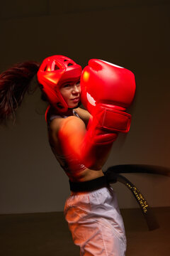 Young martial artist trains with red boxing gloves and headgear
