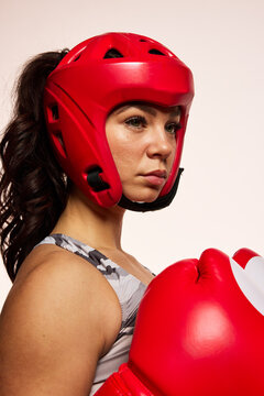 Woman prepares for boxing with red gear on a plain background