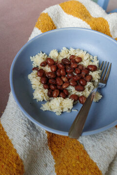 Rice and Beans Served in a Blue Bowl on a Striped Cloth