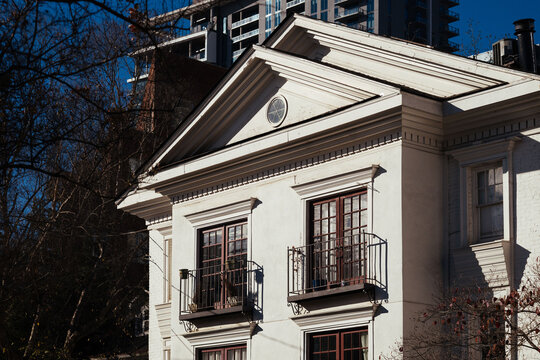 White neoclassical building with modern high-rises in background