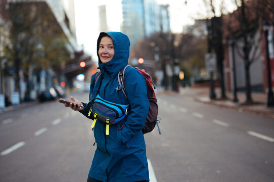 Woman smiling while standing in quiet city street