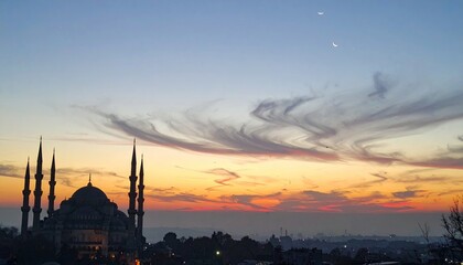 Fototapeta premium Majestic mosque silhouetted against a sunset sky with crescent moons
