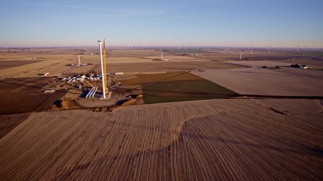 Aerial shot of windmill construction shaping the Illinois countryside