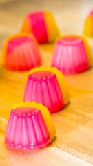 Colorful gelatin desserts in a row, with pink, orange, & yellow hues