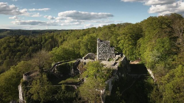 Dynamic 4K UHD drone orbit around Hohengundelfingen castle ruins above the Lauter valley, revealing rolling Swabian Alb hills, forests, and blue skies.