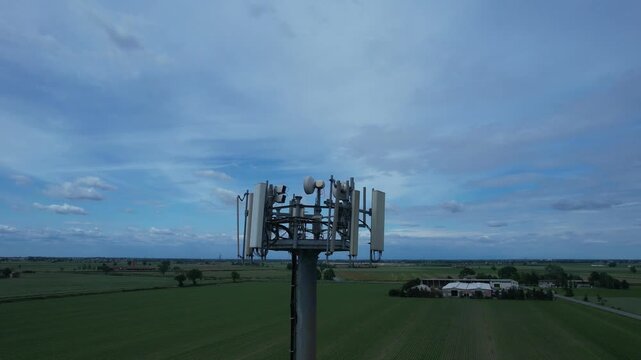 5G cellular base station tower showing multiple sector panel antennas, remote radio units, mounting brackets, and cabling, illustrating modern mobile network infrastructure for high speed wireless