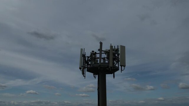 5G cellular base station tower showing multiple sector panel antennas, remote radio units, mounting brackets, and cabling, illustrating modern mobile network infrastructure for high speed wireless