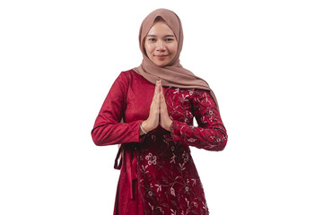 Young woman in hijab and traditional red dress with welcoming gesture smiling politely for greeting