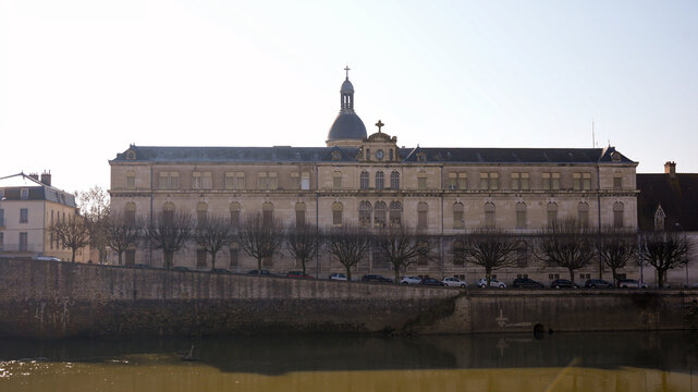 Old European architecture reflected in calm river Chalon sur Saone